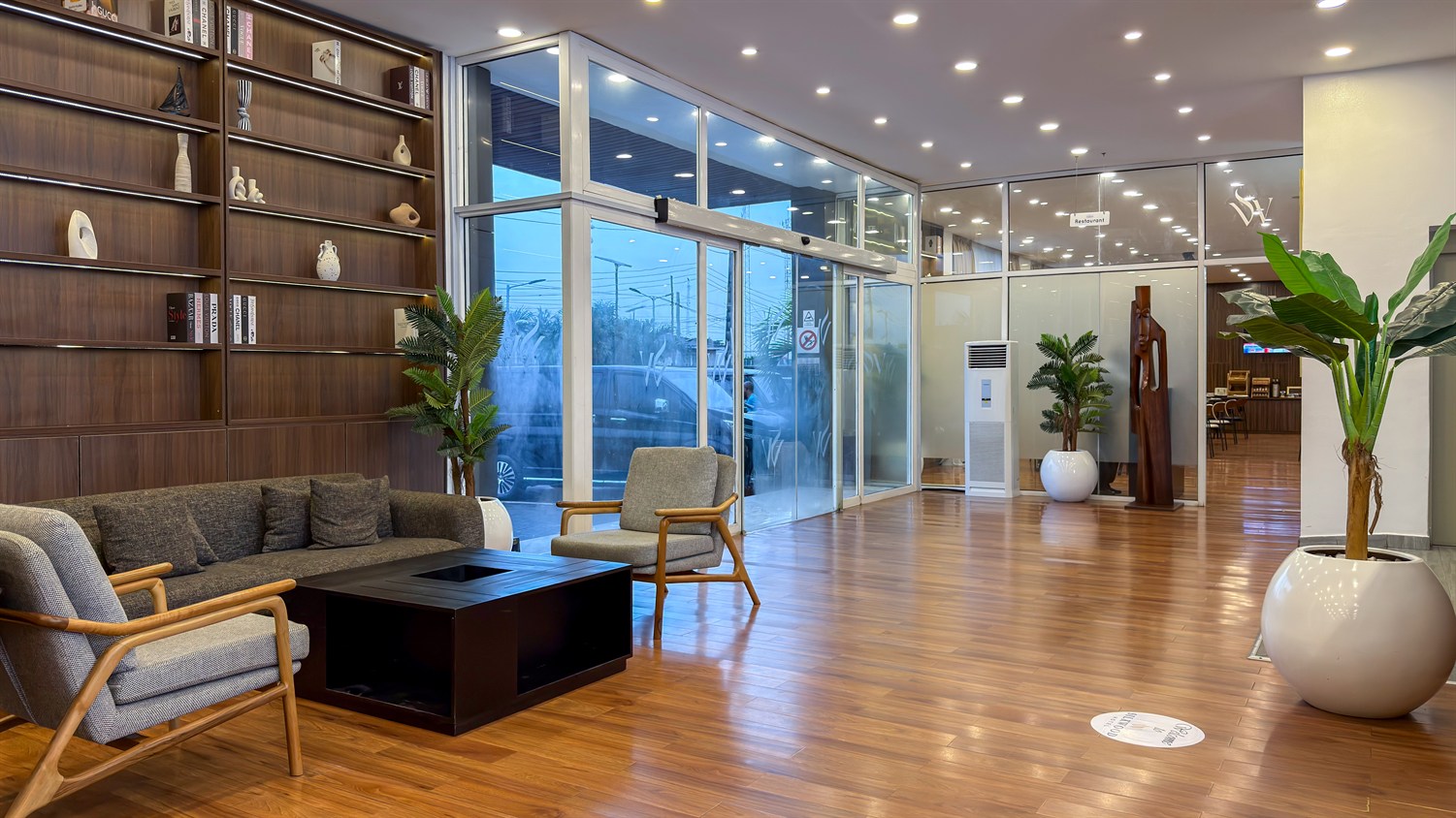 The arrival lounge, with timber shelving, soft seating and daylight from the entrance