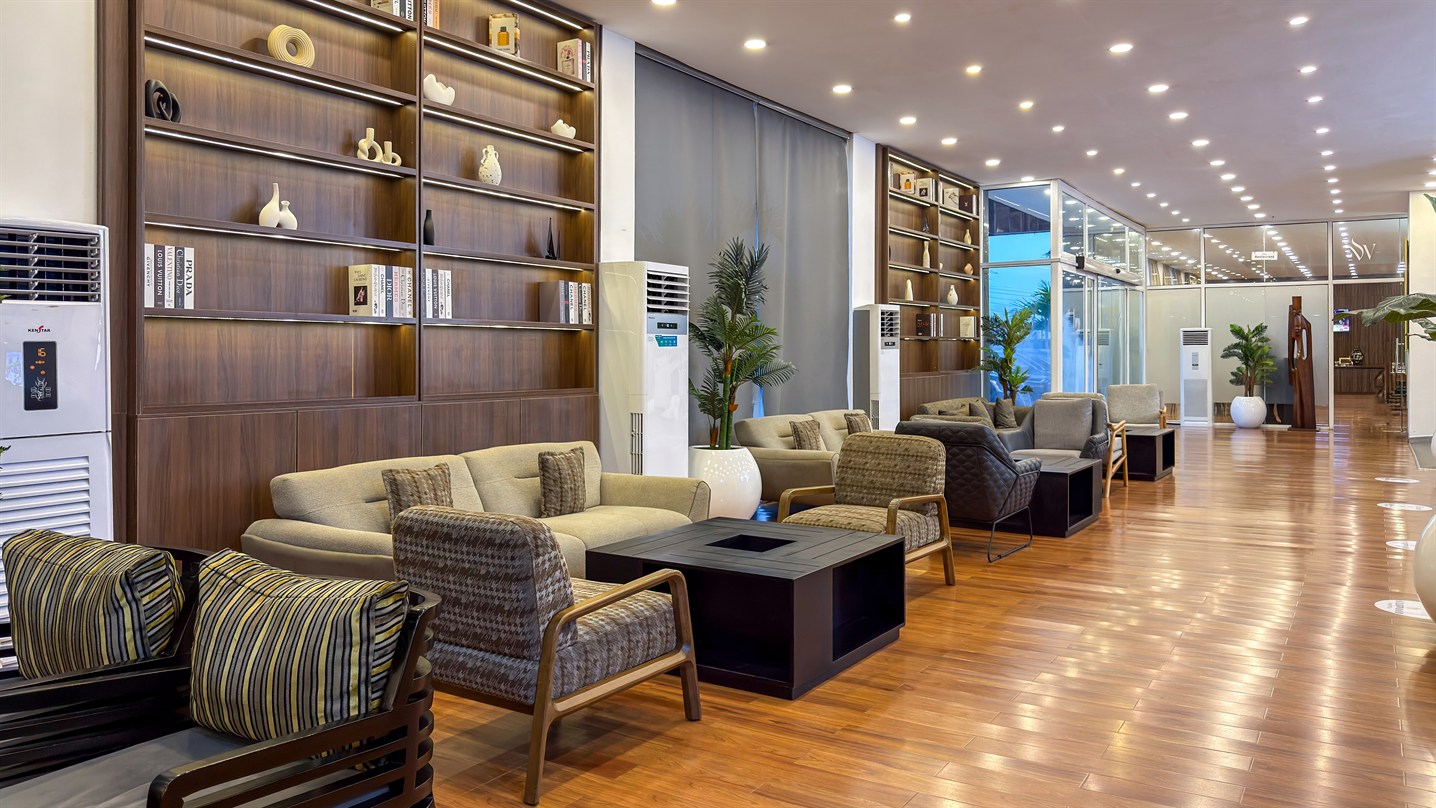 A residents' lounge with timber shelving, soft seating and daylight