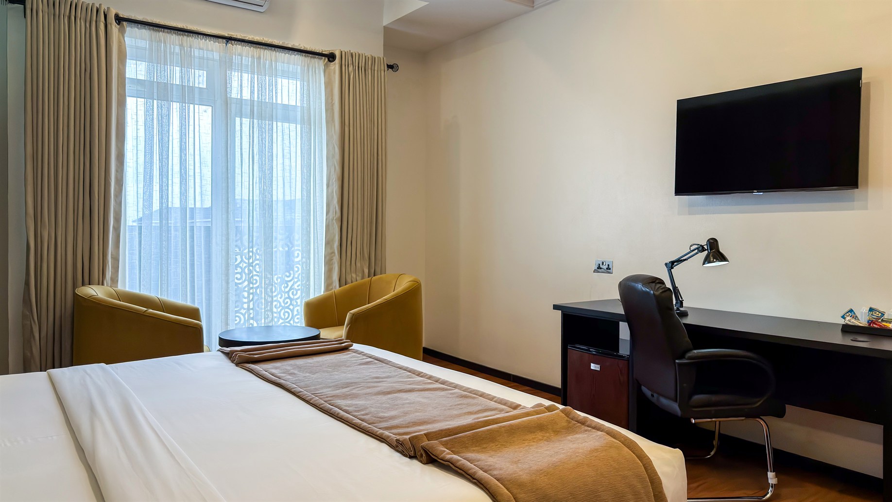 A studio suite with bed, work desk and daylight