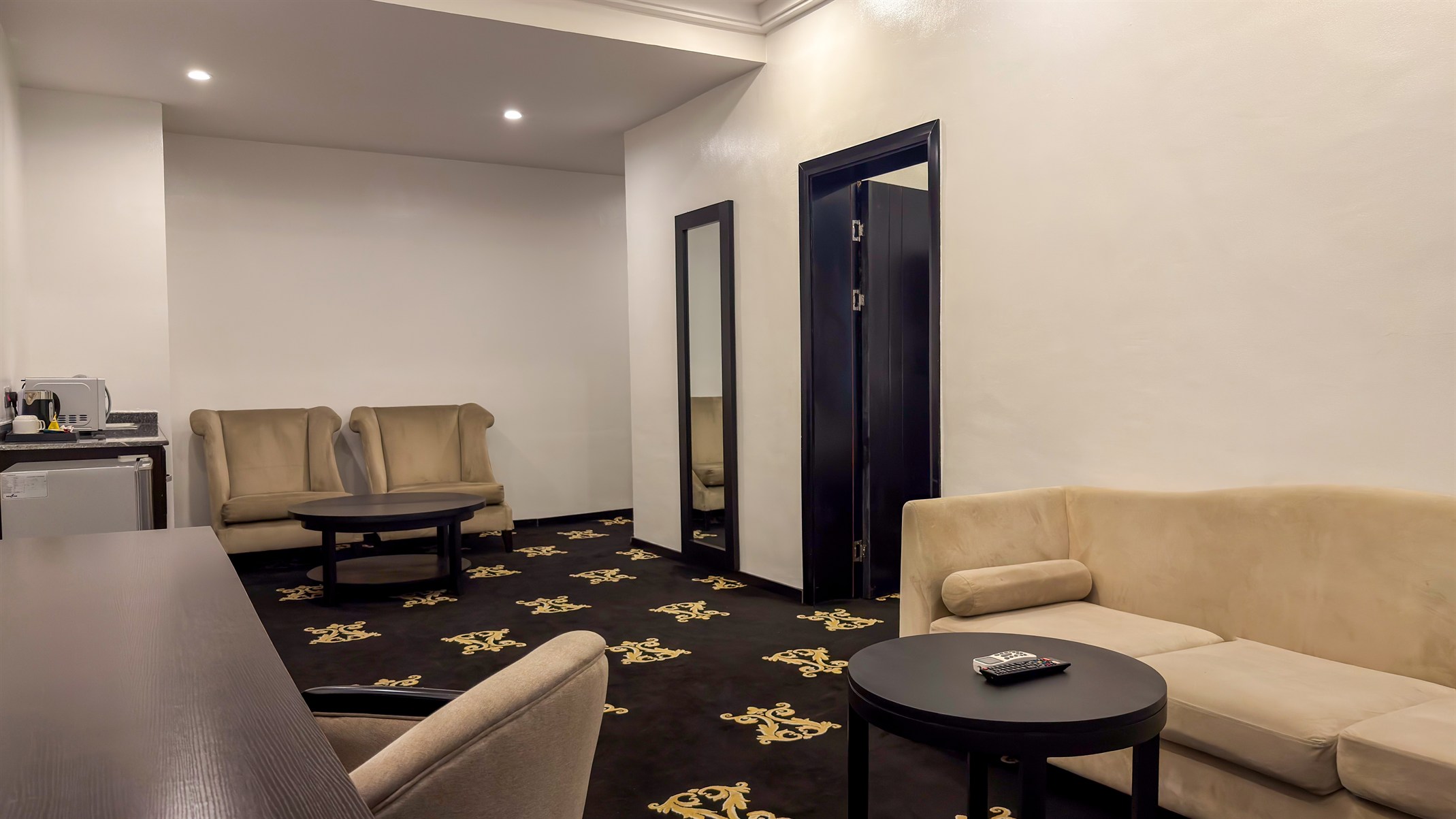 A living area with sofa, dining table and kitchenette